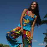 Woman wearing a colorful tropical outfit against a clear blue sky.