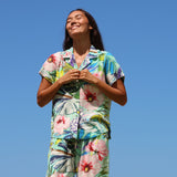 Woman wearing a colorful floral outfit against a clear blue sky