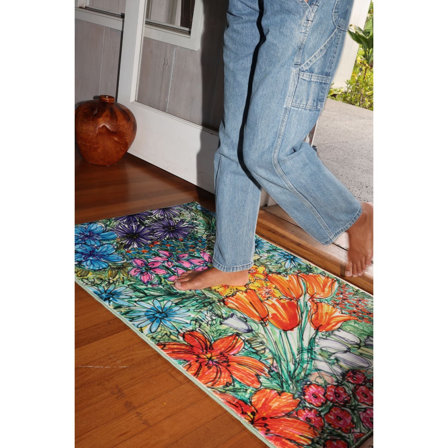 Person stepping onto a colorful floral rug with a kitchen background