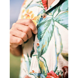 Close-up of a person wearing a colorful floral shirt with a blurred background