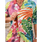 Camisa colorida con estampado de hojas tropicales usada por una persona.