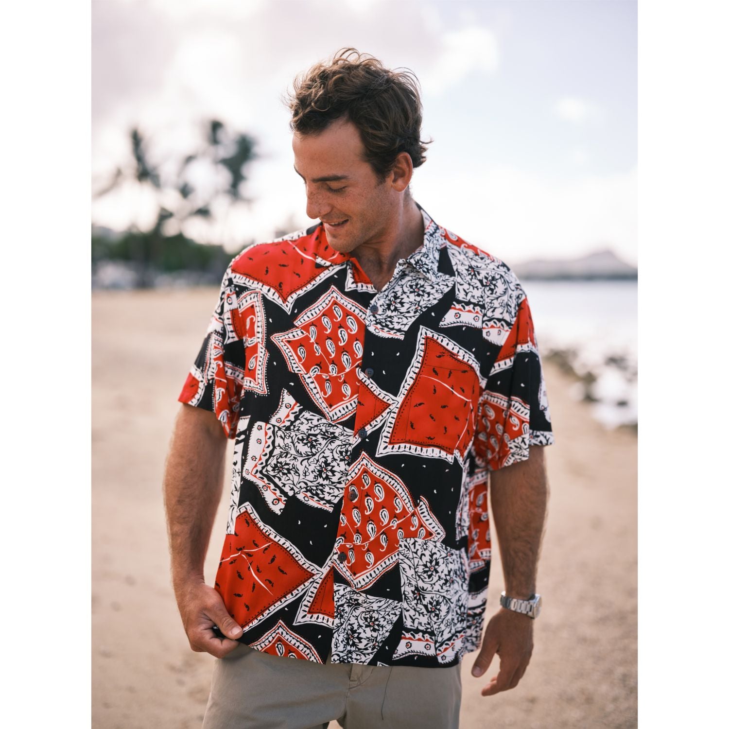 Man wearing a colorful patterned shirt on a beach