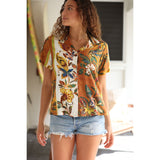 Woman wearing a colorful floral shirt and denim shorts indoors.