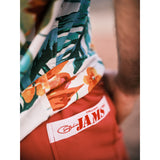 Model standing on walk way with solid red shorts with a Original Jams Label on back pocket