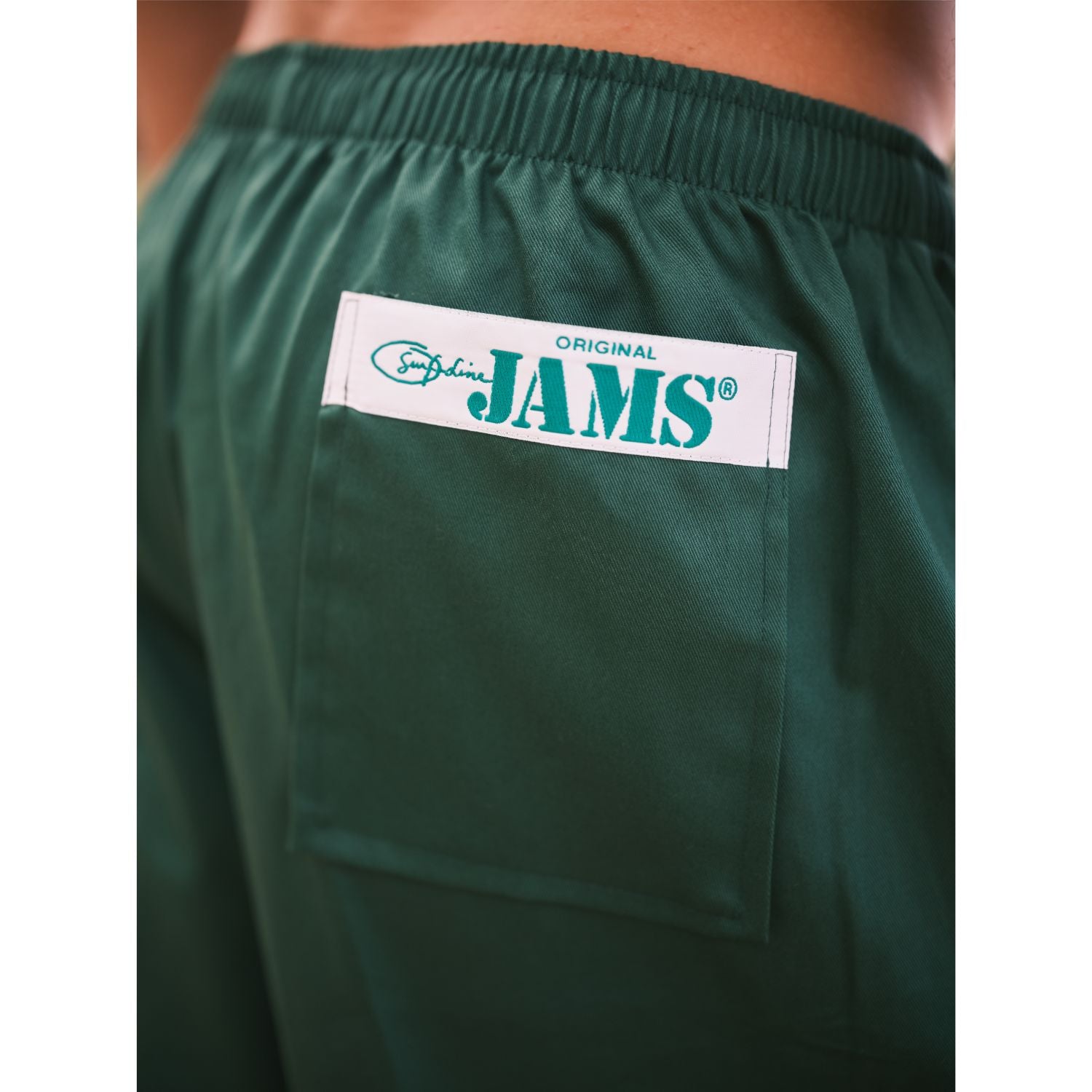 Green shorts with a 'JAMS' logo on the back pocket