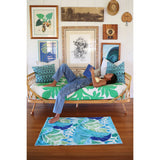 Tapete con estampado de hojas tropicales en colores azul y verde sobre fondo blanco.