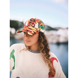 Colorful cap in our Jams World Salsa print on model standing on boat docked at pier.