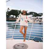 Colorful cap in our Jams World Salsa print on model standing on boat docked at pier.