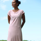 Woman wearing a pink dress against a clear blue sky