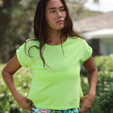 Person wearing a bright green shirt with a blurred outdoor background