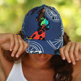 A woman wearing a navy blue baseball cap with a colorful graphic print and white bicycle line patterns, holding the brim down over her eyes.