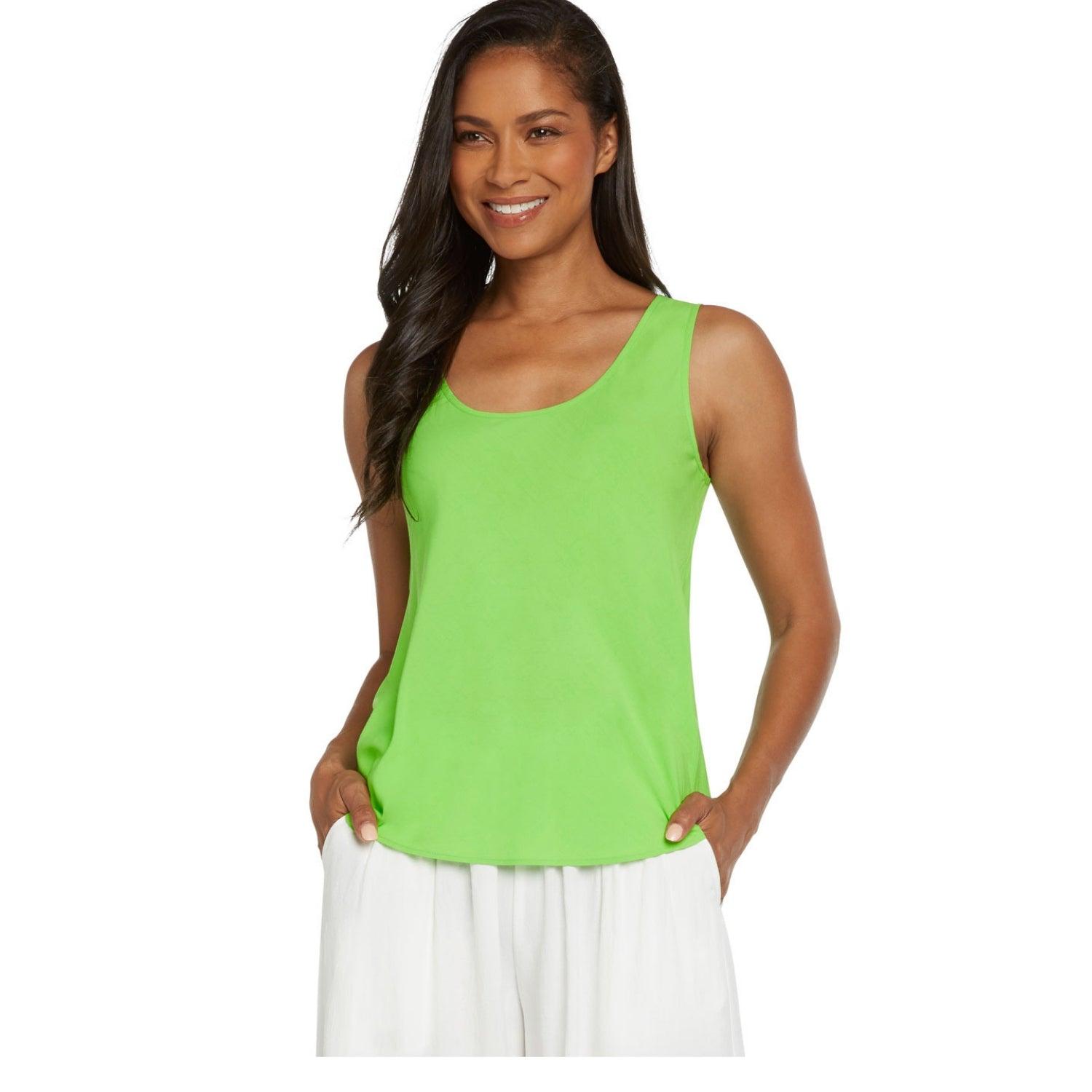 A woman modeling a bright lime green scoop-neck tank top with white pants, set against a plain white background.