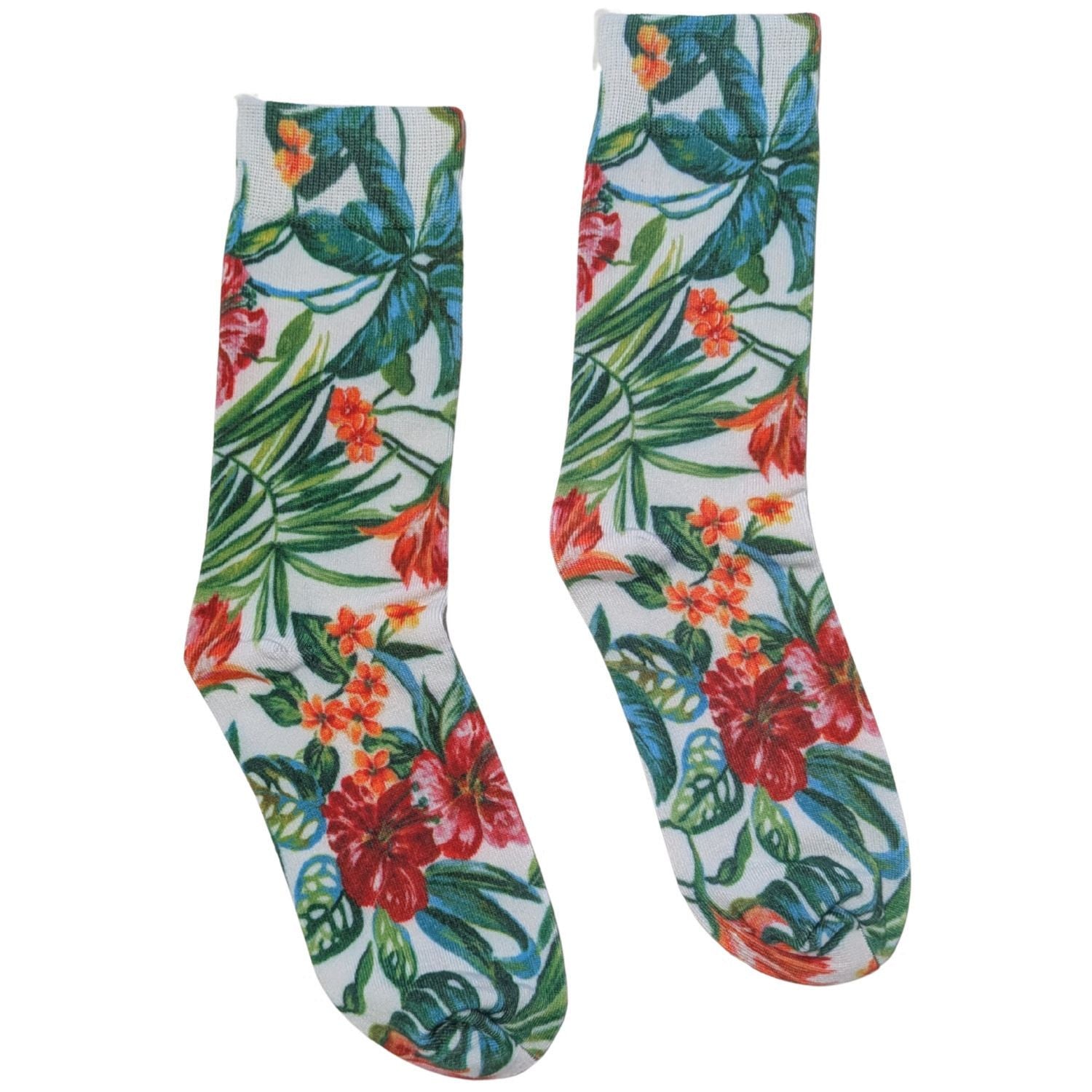 A pair of crew socks with a vibrant tropical floral and leaf print on a white background, featuring red hibiscus flowers, orange blossoms, and green palm leaves.