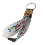 A woven fabric keychain strap with a metal key ring, featuring the colorful text 'JAMS WORLD HONOLULU' printed on a white background with a multicolor patterned section.