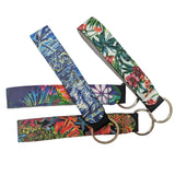 Three fabric wristlet keychains with metal key rings, displayed on a solid white background. Each keychain features a different vibrant tropical and Polynesian-inspired pattern in blue, red, green, and yellow.