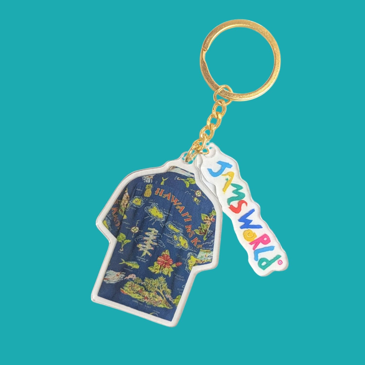 A Jamsworld keychain featuring a blue graphic t-shirt charm and a white 'Jamsworld' brand tag, attached to a gold split ring on a solid teal background.