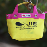 Yellow bag with pink handles featuring JIB branding and text, hanging on a branch.