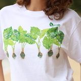 White t-shirt with green leaf design and 'Kolan' logo worn by a person.