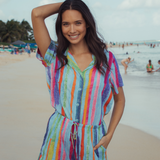 Woman in a colorful striped top and pants on a beach