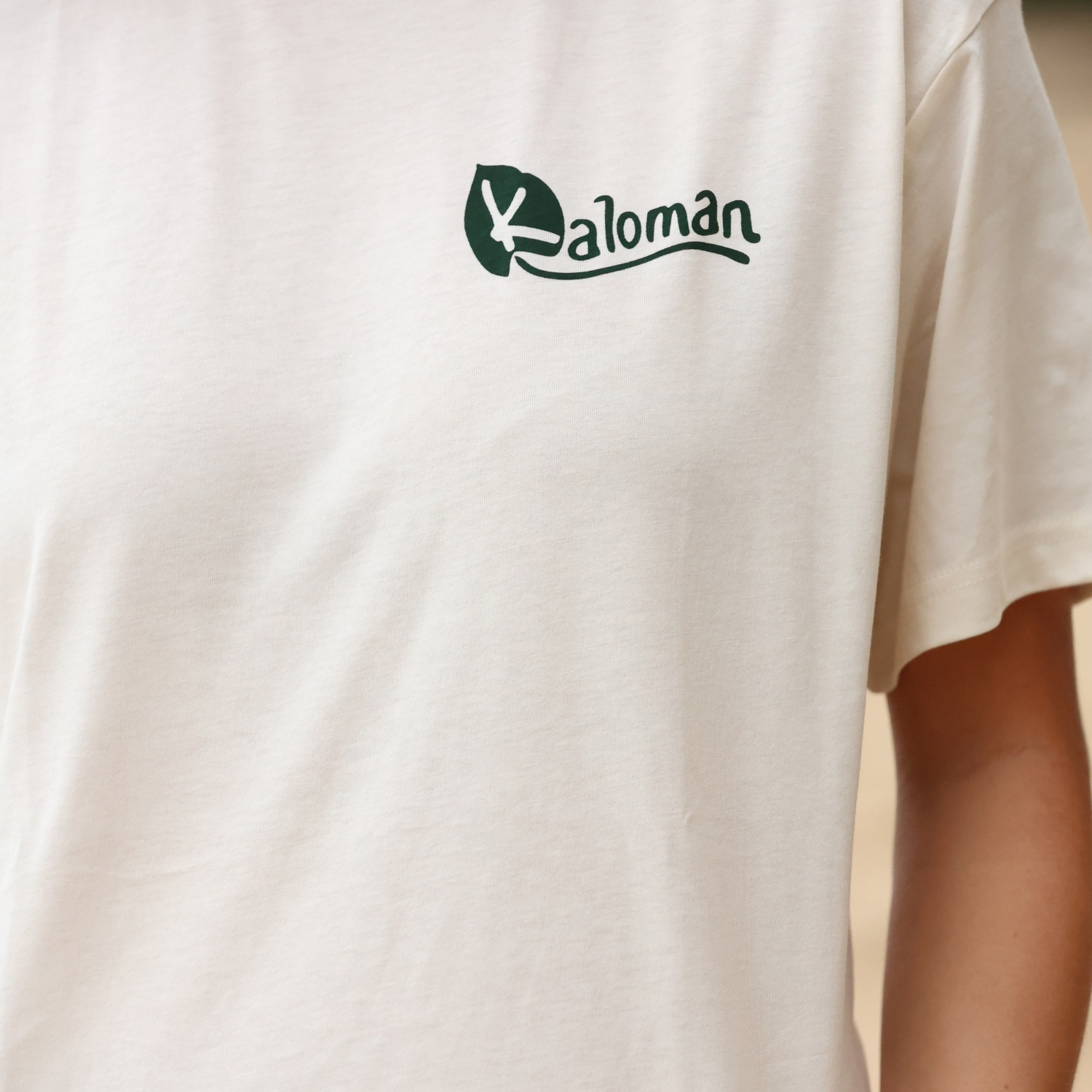 White t-shirt with a brand logo on the chest against a neutral background