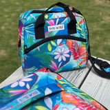 Colorful floral-patterned cooler bag with 'Snug as a Bug' label on a wooden surface.