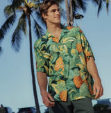 Man wearing a tropical pineapple shirt with palm trees in the background